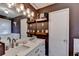 Bathroom with double sinks, stone countertops, floating shelves, and decorative lighting at 8530 Hightower Trl, Snellville, GA 30039