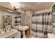 Bathroom featuring a double sink, vanity lighting, large mirror, and a shower behind a striped curtain at 8530 Hightower Trl, Snellville, GA 30039