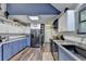 Modern kitchen with blue and white cabinets, subway tile backsplash, and wood floors at 8530 Hightower Trl, Snellville, GA 30039