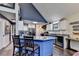 Kitchen island with bar stools and blue cabinets, complete with a wine fridge at 8530 Hightower Trl, Snellville, GA 30039