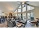 Bright living room featuring vaulted ceilings, large windows, and a comfortable gray sectional sofa with an ottoman at 8530 Hightower Trl, Snellville, GA 30039