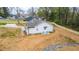 Aerial view of house features a gravel driveway and backyard with trees and a wooden fence at 5747 S Gordon Rd, Austell, GA 30168