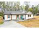 Charming one story home featuring a freshly painted white exterior with a welcoming cyan front door at 5747 S Gordon Rd, Austell, GA 30168
