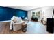 Comfortable living room with a striking blue accent wall, stylish furnishings, and wood grain flooring at 5747 S Gordon Rd, Austell, GA 30168