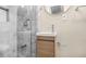 Modern bathroom features a walk-in shower with gray tile and a stylish vanity with round mirror at 1910 Thompson Ave, East Point, GA 30344