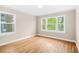 Bright bedroom with hardwood floors and a view of the lush greenery outside at 1910 Thompson Ave, East Point, GA 30344