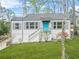 Charming single-story home featuring a bright blue front door, lush green lawn, and lovely landscaping at 1910 Thompson Ave, East Point, GA 30344