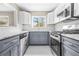 Updated kitchen with stainless steel appliances, granite countertops and backsplash and gray lower cabinets at 1910 Thompson Ave, East Point, GA 30344