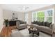 Staged living room with neutral tones, hardwood floors, and large windows providing natural light at 1910 Thompson Ave, East Point, GA 30344