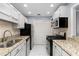 Galley kitchen featuring granite counters, stainless steel appliances, and white tile flooring at 303 Gettysburg Pl, Atlanta, GA 30350