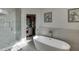 Elegant bathroom with soaking tub, glass shower, and walk-in closet at 4880 Stone Moss Path, Hoschton, GA 30548