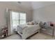 Bright bedroom with a comfortable bed, vanity, and large window for plenty of natural light at 4880 Stone Moss Path, Hoschton, GA 30548