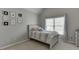 Cozy bedroom with a twin bed, framed art, and bright natural light from the large window at 4880 Stone Moss Path, Hoschton, GA 30548