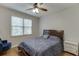 Cozy bedroom with a ceiling fan, hardwood floors, and a window providing natural light at 4880 Stone Moss Path, Hoschton, GA 30548