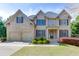 Traditional two-story brick home with a two-car garage, landscaped front yard, and inviting entrance at 4880 Stone Moss Path, Hoschton, GA 30548