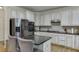 Bright kitchen boasts stainless steel appliances, granite countertops, and ample cabinet space at 4880 Stone Moss Path, Hoschton, GA 30548