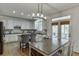 Bright kitchen with an island, stainless steel appliances, stylish lighting, and access to an outdoor space at 4880 Stone Moss Path, Hoschton, GA 30548
