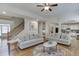 Open-concept living room featuring hardwood floors, neutral furnishings, and seamless access to the kitchen at 4880 Stone Moss Path, Hoschton, GA 30548