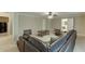 Spacious living room features neutral walls, carpet, ceiling fan, and comfortable, oversized wraparound couch at 4880 Stone Moss Path, Hoschton, GA 30548