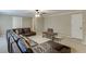 Spacious living room features neutral walls, carpet, ceiling fan, and comfortable, oversized wraparound couch at 4880 Stone Moss Path, Hoschton, GA 30548