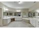 Large, neutral-colored main bathroom with dual sinks, soaking tub, tiled floor, and lots of light at 4880 Stone Moss Path, Hoschton, GA 30548
