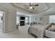 Spacious primary bedroom with tray ceiling, fireplace, and sitting area, illuminated by natural light at 4880 Stone Moss Path, Hoschton, GA 30548