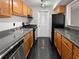 Galley kitchen featuring sleek black tile floors, and light wood cabinets at 4640 Vinings Central Se Run # 128, Atlanta, GA 30339