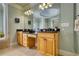 Bathroom with a double sink vanity with wood cabinets, granite countertop, and large mirror at 4777 Ardmore Ln, Hoschton, GA 30548