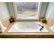 Close-up of a soaking tub with jets, window, and tile surround at 4777 Ardmore Ln, Hoschton, GA 30548