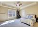 Bedroom with a tray ceiling, large window, and neutral color scheme at 4777 Ardmore Ln, Hoschton, GA 30548