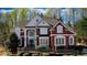 Stately brick home with manicured landscaping, large windows, and an elegant entrance framed by white pillars at 4777 Ardmore Ln, Hoschton, GA 30548