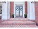 Elegant front entryway featuring double doors with glass panels, decorative wreaths, and stately white columns at 4777 Ardmore Ln, Hoschton, GA 30548