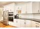Modern kitchen featuring stainless steel appliances, sleek white cabinets, and dark granite countertops at 4777 Ardmore Ln, Hoschton, GA 30548