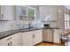 Charming kitchen showcasing white cabinets, stainless steel appliances, granite counters, and a garden view at 4777 Ardmore Ln, Hoschton, GA 30548
