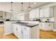 Bright kitchen featuring white cabinetry, granite countertops, hardwood floors, and modern pendant lighting at 4777 Ardmore Ln, Hoschton, GA 30548