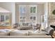 Elegant living room featuring a stone fireplace, hardwood floors, and natural light from large windows at 4777 Ardmore Ln, Hoschton, GA 30548