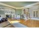 Open-concept living space with hardwood floors, a staircase, and an adjacent dining area with large windows at 4777 Ardmore Ln, Hoschton, GA 30548