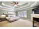Spacious main bedroom featuring a decorative trey ceiling, fireplace, and plush carpeting at 4777 Ardmore Ln, Hoschton, GA 30548