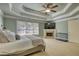 Spacious main bedroom featuring a decorative trey ceiling, fireplace, and plush carpeting at 4777 Ardmore Ln, Hoschton, GA 30548