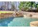 Sparkling pool with lush greenery and retaining walls providing privacy and creating a serene outdoor escape at 4777 Ardmore Ln, Hoschton, GA 30548