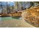 Tranquil pool featuring a stone waterfall and lush landscaping, offering a serene retreat in the backyard at 4777 Ardmore Ln, Hoschton, GA 30548