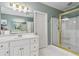 Bathroom featuring a walk-in shower with gold trim and a double vanity with white cabinets at 1142 Hidden Spirit Trl, Lawrenceville, GA 30045
