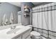 Well-lit bathroom showcases a white vanity, decorative shelves, and a stylish shower curtain at 1142 Hidden Spirit Trl, Lawrenceville, GA 30045
