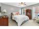 Bedroom featuring a ceiling fan, a bed with patterned pillows, and a vintage cabinet at 1142 Hidden Spirit Trl, Lawrenceville, GA 30045