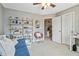Bedroom featuring a loveseat, ceiling fan, and built in shelving with a view into the hallway at 1142 Hidden Spirit Trl, Lawrenceville, GA 30045