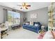 Cozy bedroom with large window, loveseat, ceiling fan, and neutral walls at 1142 Hidden Spirit Trl, Lawrenceville, GA 30045