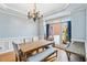 Elegant dining room with chandelier, trim detail, and large window with neighborhood view at 1142 Hidden Spirit Trl, Lawrenceville, GA 30045