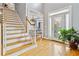Bright foyer featuring wood floors, staircase, chandelier, and natural light at 1142 Hidden Spirit Trl, Lawrenceville, GA 30045