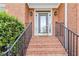 Inviting front porch with brick steps and iron railings, perfect for enjoying the outdoors at 1142 Hidden Spirit Trl, Lawrenceville, GA 30045