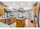 Open kitchen with light wood cabinets, gas cooktop island, stainless steel appliances, and access to backyard at 1142 Hidden Spirit Trl, Lawrenceville, GA 30045